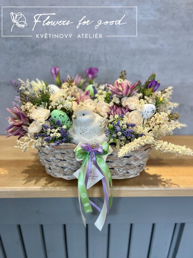 Velikonoční ošatka s ptáčkem v hnízdě mezi květinami