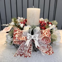 Svícen s krásnou mašlí na dřevěném hnízdě s umělým jehličím